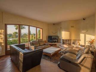 Experience luxurious living in this spacious living room, featuring comfortable leather seating and a cozy fireplace.