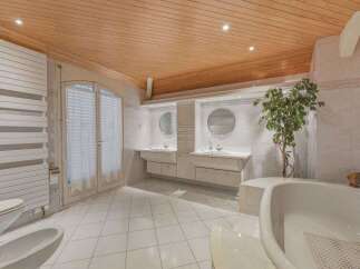 This spacious bathroom features a luxurious freestanding bathtub, perfect for a relaxing soak.