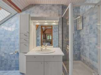 This charming bathroom features a spacious shower with a bathtub, perfect for relaxing after a long day.