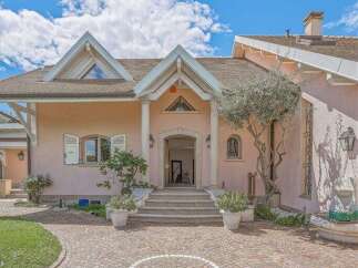 Discover this charming peach-colored home featuring a grand entrance with elegant columns and a welcoming staircase.