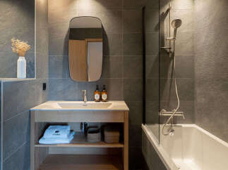 Experience modern comfort in this stylish bathroom, featuring a sleek vanity with a spacious sink and ample storage.