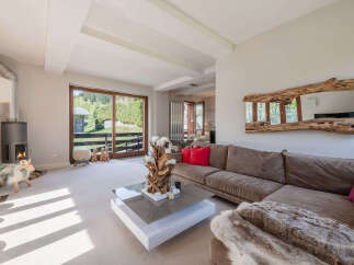 Experience cozy living in this spacious living room featuring a modern fireplace and large sliding glass doors that open to a scenic view.