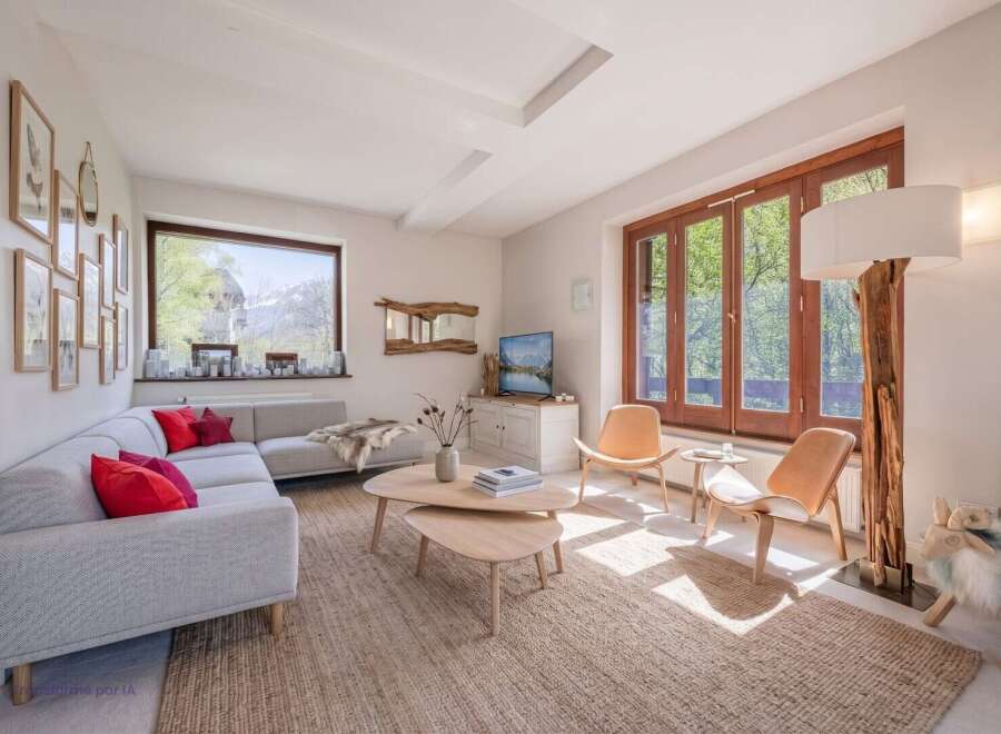 Experience breathtaking mountain views from this stunning living room, featuring a spacious sectional sofa adorned with vibrant red pillows and a cozy faux fur throw.