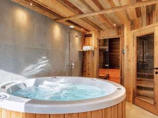 Indulge in ultimate relaxation in this luxurious bathroom featuring a spacious hot tub and a separate sauna.