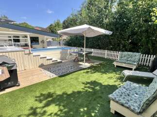 Enjoy ultimate relaxation in this backyard oasis featuring a sparkling swimming pool and a spacious deck perfect for entertaining.