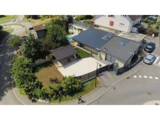Discover this modern home featuring a sleek metal roof and solar panels, perfect for eco-conscious living.
