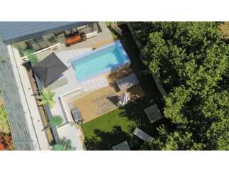 Experience luxury outdoor living with this stunning property featuring a pristine swimming pool and a spacious wooden deck.