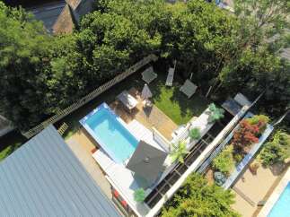 Experience ultimate relaxation in this stunning backyard oasis, featuring a pristine swimming pool and a spacious wooden deck perfect for sunbathing and entertaining.