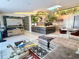 Experience modern living in this stunning open-plan space, featuring a sleek kitchen island and a vibrant dining area perfect for entertaining.