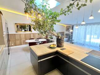 Experience modern living in this open-concept kitchen and living area, featuring a sleek island with a built-in stovetop and ample counter space.