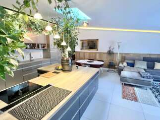 Experience modern living in this open-concept space, featuring a sleek kitchen island with a built-in stovetop and a spacious living area perfect for relaxation.