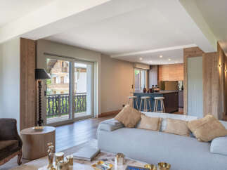 Experience modern alpine living in this stunning open-concept apartment, featuring a spacious living area with a comfortable sofa and a sleek kitchen island perfect for entertaining.