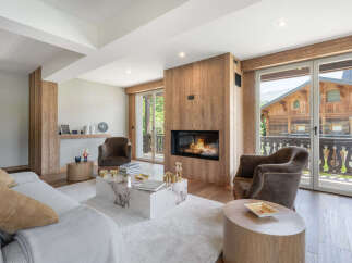 Experience luxury mountain living in this stunning living room, featuring a modern fireplace set against a warm wood-paneled accent wall.