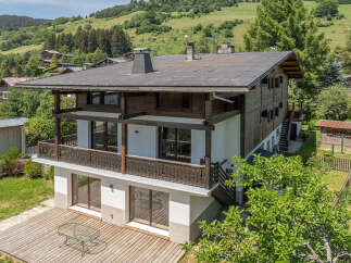 Experience alpine living in this charming wooden chalet, nestled amidst rolling green hills and picturesque mountain scenery.