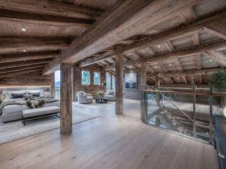 Experience luxurious mountain living in this stunning chalet-style bedroom, featuring exposed wooden beams and a cozy, rustic ambiance.