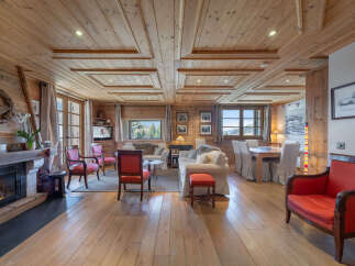 Experience rustic luxury in this charming mountain chalet living room, featuring a crackling fireplace and warm wooden interiors.