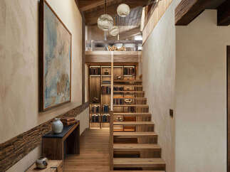 Discover this stunning entryway featuring a rustic wooden staircase leading to a cozy loft space.