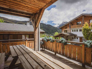 Enjoy breathtaking mountain views from this charming wooden balcony, complete with a picnic table and barbecue grill.