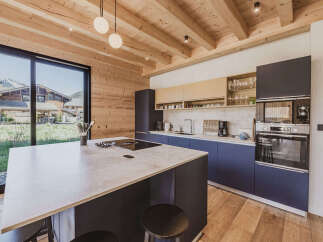 Experience modern mountain living in this stunning kitchen featuring a spacious island with a built-in cooktop and ample seating.