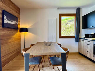 Experience modern mountain living in this beautifully appointed dining area, featuring a sleek wooden table and comfortable seating.