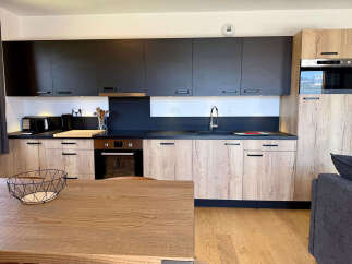 Experience modern living in this sleek kitchen featuring dark upper cabinets contrasted with light wood lower cabinets.