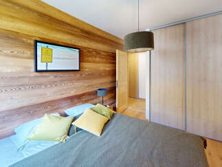 Experience cozy mountain living in this charming bedroom featuring warm, natural wood paneling on the walls.