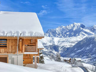 Experience the ultimate alpine retreat in this stunning wooden chalet, perfectly situated amidst snow-covered mountains.