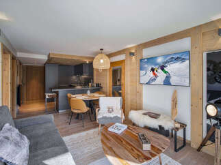 Experience modern alpine living in this beautifully appointed apartment, featuring a sleek, integrated kitchen and a cozy dining area perfect for family meals.