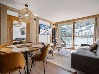 Experience mountain living in this charming apartment featuring a cozy dining area with a rustic wooden table and plush seating.