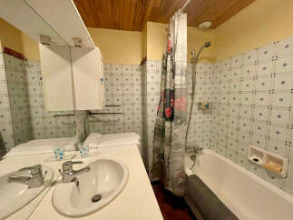 This bathroom features a practical layout with a bathtub and shower combination, perfect for families.