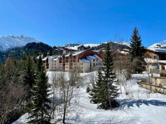 Experience the charm of this alpine village with its picturesque ski resort architecture nestled amidst snow-covered mountains.