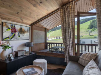 Experience the ultimate mountain retreat in this charming living room, featuring a large flat-screen TV displaying a thrilling ski race.
