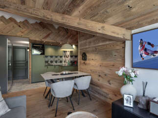 Experience alpine living in this charming dining area, featuring a rustic wooden ceiling and walls that exude warmth and character.