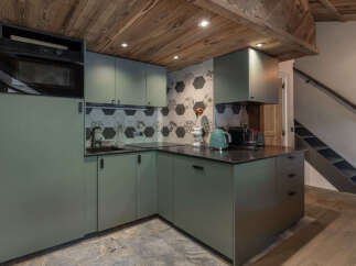 Discover this charming kitchen featuring modern sage green cabinetry and a stylish hexagonal tile backsplash.