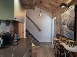 Experience rustic charm in this mountain-inspired home, featuring a modern kitchen with sleek cabinetry and a striking hexagonal tile backsplash.