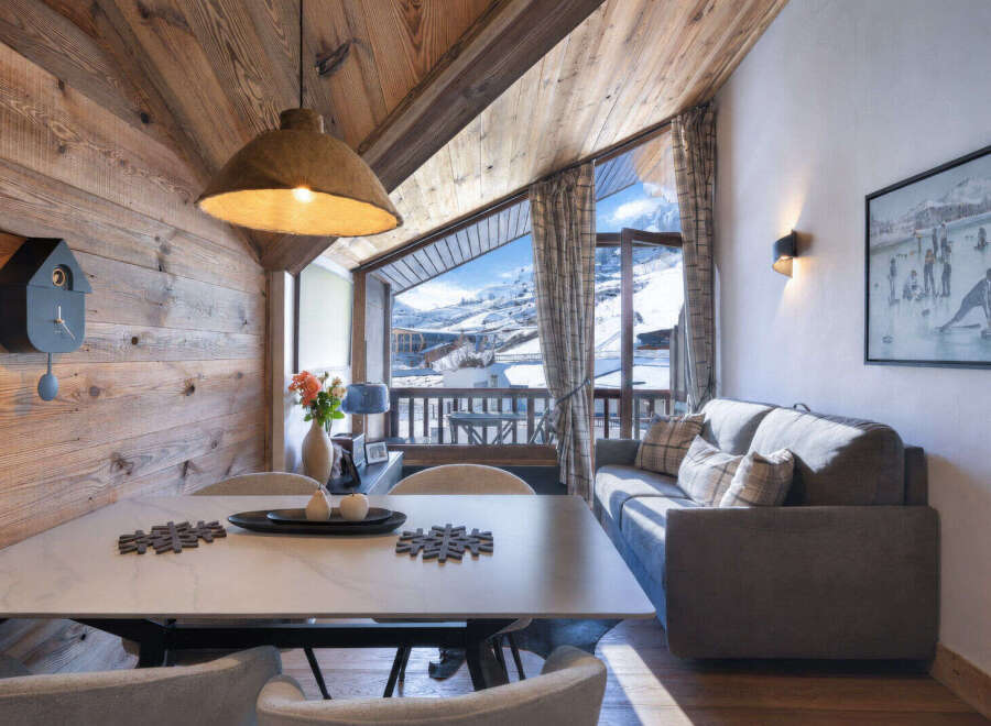 Experience cozy mountain living in this charming alpine retreat, featuring a rustic wooden interior and breathtaking panoramic views of snow-capped peaks.