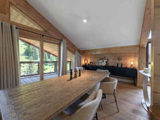 Experience luxurious mountain living in this stunning dining room, featuring a grand wooden table perfect for gatherings.