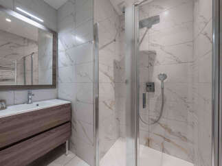 Experience modern luxury in this beautifully appointed bathroom, featuring a spacious walk-in shower with elegant marble-patterned tiles.