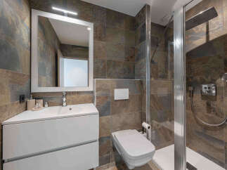 Experience modern luxury in this stunning bathroom featuring a sleek vanity with a crisp white sink and ample storage.