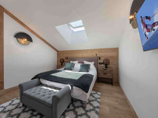 Experience ultimate comfort in this charming bedroom, featuring a plush king-size bed adorned with soft pillows and a cozy duvet.
