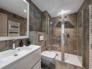 Experience modern luxury in this stunning bathroom, featuring a sleek vanity with a vessel sink and a spacious walk-in shower with elegant tilework.