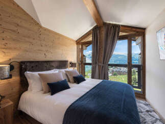 Experience luxurious mountain living in this stunning bedroom featuring a cozy king-size bed with plush bedding and a fur headboard.