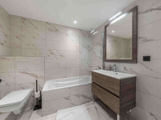 Experience modern luxury in this stunning bathroom, featuring elegant marble-patterned tiles that create a sophisticated ambiance.