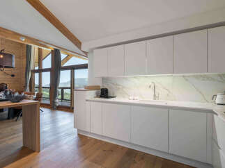 Experience modern luxury in this stunning kitchen, featuring sleek white cabinetry and a striking marble backsplash.
