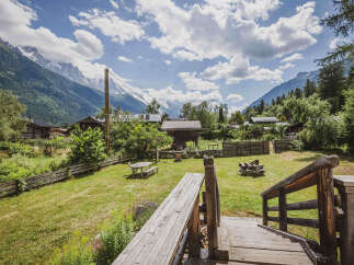 Experience the charm of mountain living with this picturesque property, featuring a cozy wooden cabin nestled amidst lush greenery and offering breathtaking views of snow-capped peaks.