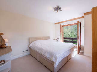 Experience serene living in this charming bedroom, featuring a comfortable bed with a plush duvet and a stylish headboard.