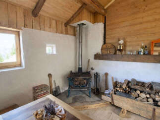 Experience rustic charm in this cozy cabin featuring a traditional wood-burning stove, perfect for warming up after a day outdoors.
