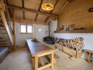Experience rustic charm in this cozy cabin featuring a spacious wooden dining table perfect for family gatherings.