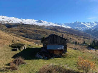 Discover this charming stone cabin nestled in a serene mountain landscape, perfect for a rustic getaway.