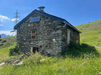 Discover this charming stone cabin nestled in a serene mountain landscape, perfect for a rustic retreat.